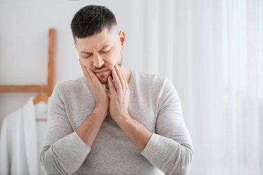 Sabahları diş ağrısı çeken bir adam.