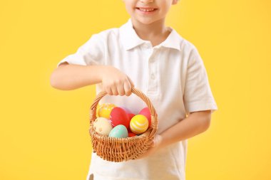 Renkli Paskalya yumurtaları olan sevimli küçük bir çocuk.