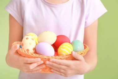 Renkli arka planda Paskalya yumurtaları olan sevimli küçük kız, yakın plan.