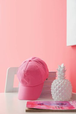 Şapkalı masa, kitaplar ve renk duvarının yanındaki dekor.