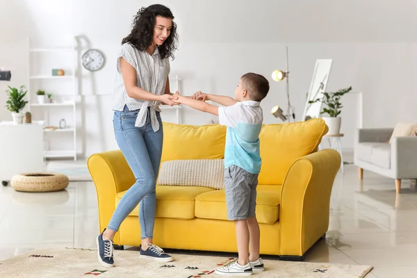 Mutlu kadın ve küçük oğlu evde dans ediyor.