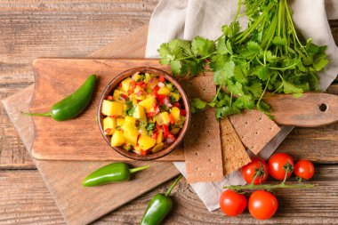 Ahşap arka planda taze mango soslu kase.