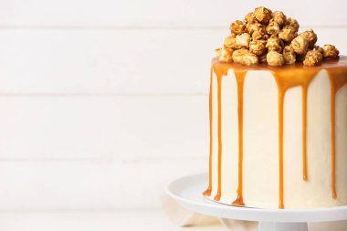 Patlamış mısırlı lezzetli pasta ve açık ahşap zemin üzerinde karamel.