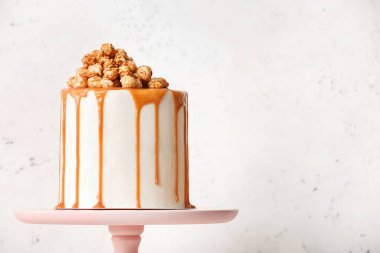 Patlamış mısır ve açık arkaplanda karamel olan lezzetli bir pasta.