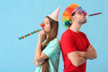 Renkli arka planda tuhaf kılık değiştirmiş genç bir çift. 1 Nisan şakası