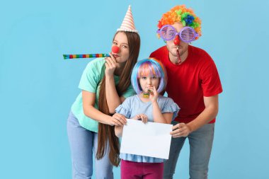 Komik kılık değiştirmiş genç bir aile ve renkli arka planda boş kağıt kağıtları var. 1 Nisan şakası