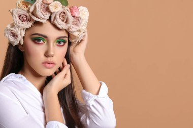 Yaratıcı makyajlı güzel bir genç kadının portresi ve kafasının üzerinde renkler var.