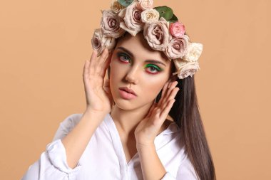 Yaratıcı makyajlı güzel bir genç kadının portresi ve kafasının üzerinde renkler var.