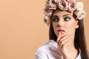 Yaratıcı makyajlı güzel bir genç kadının portresi ve kafasının üzerinde renkler var.