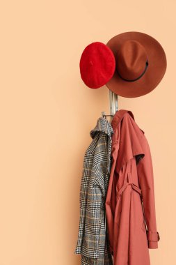 Salondaki renkli duvarın yanında bahar giysileri olan askı.