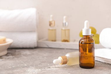 Gri arka planda üzüm tohumu yağı ve banyo malzemeleri.