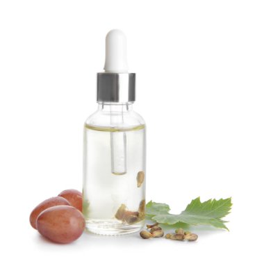 Beyaz arka planda bir şişe üzüm tohumu yağı.