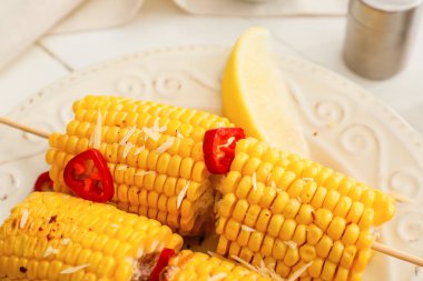 Hafif arka planda lezzetli fırınlanmış mısır koçanı tabağı.