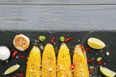 Lezzetli mısır koçanı ve ahşap arka planda sarımsak olan bir tahta.