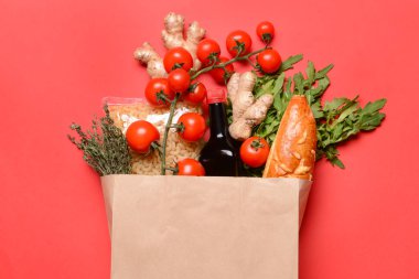 Renkli arka planda farklı ürünlere sahip kağıt torba