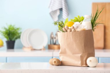 Mutfaktaki masada farklı ürünlerin olduğu kağıt torba.