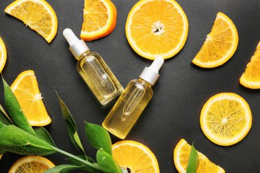 Koyu arkaplanda portakal yağı şişeleri