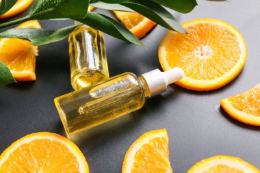 Koyu arkaplanda portakal yağı şişeleri