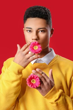 Renkli arka planda çiçekleri olan yakışıklı bir gencin portresi.