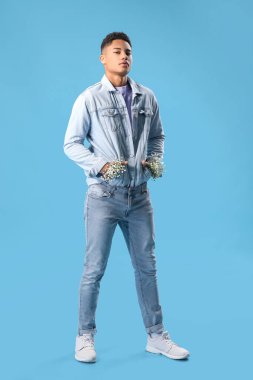 Renkli arka planda çiçekleri olan yakışıklı bir gencin portresi.