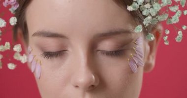 Saçında bahar çiçekleri olan güzel genç bir kadın, yakın plan.