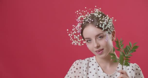 Красивая Молодая Женщина Весенними Цветами Волосах Зелеными Ветвями Цветном Фоне — стоковое видео