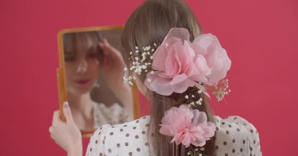Schöne Junge Frau Mit Frühlingsblumen Haar Spiegel Vor Farbigem Hintergrund — Stockvideo