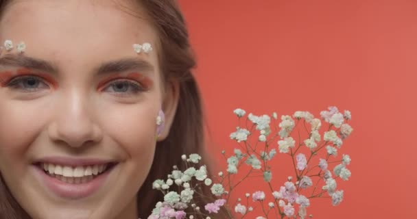 美丽的年轻女子 有着富有创意的春妆和色彩艳丽的花朵背景 — 图库视频影像