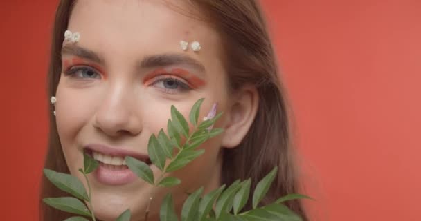 Красива Молода Жінка Креативним Весняним Макіяжем Зеленими Гілками Кольоровому Фоні — стокове відео