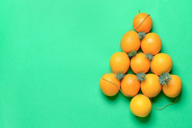 Arkaplanda portakallardan yapılmış Noel ağacı