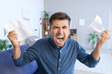 Evdeki stresli genç adamın portresi.