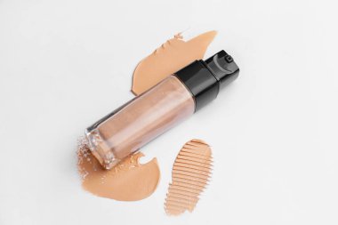 Bir şişe makyaj vakfı ve beyaz arkaplanda örnekler