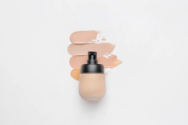 Bir şişe makyaj vakfı ve beyaz arkaplanda örnekler