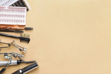 Takma kirpikli bileşim ve renk arkaplanındaki araçlar