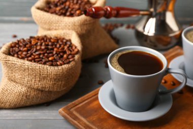 Koyu ahşap arka planda bir fincan sıcak kahveli kompozisyon