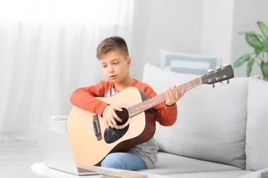 Küçük çocuk evde müzik dersleri alıyor.