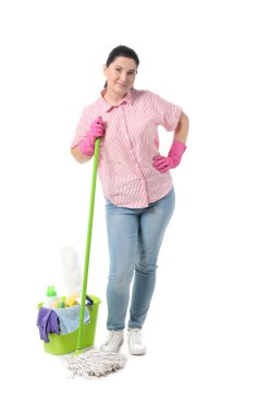 Beyaz arka planda temizlik malzemeleri ve yer paspası olan olgun bir kadın.