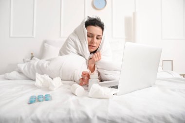 Evde çalışan dizüstü bilgisayarı olan hasta genç bir kadın.