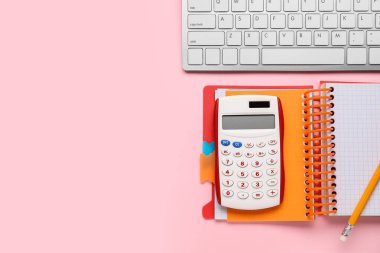 Renk arkaplanı üzerinde dizüstü ve bilgisayar klavyesi olan hesap makinesi