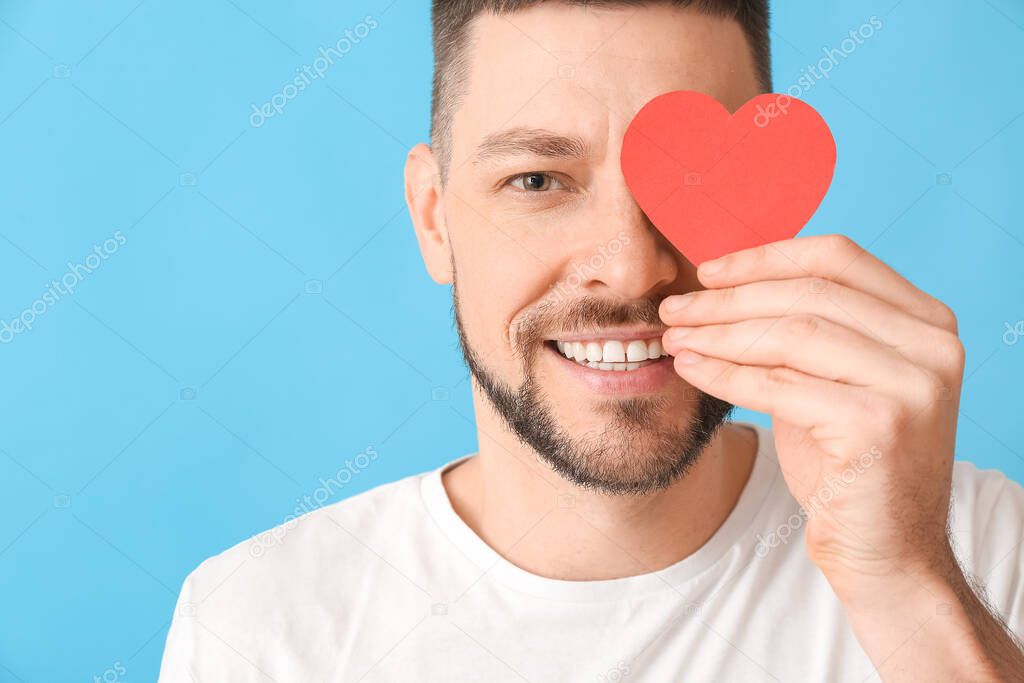 Man with red heart on color background