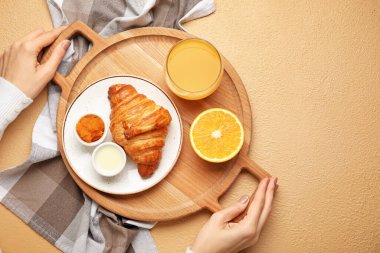 Elinde ahşap tepsi ve nefis kahvaltılı bir kadın var.