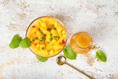 Mango sosu ve hafif arkaplanlı meyve salatası.