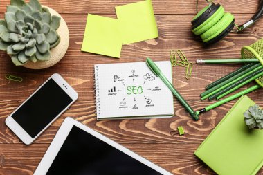 Masasında kırtasiye malzemesi olan modern cihazlar. SEO kavramı