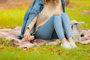 Termoslu genç bir kadın sıcak çay içiyor.