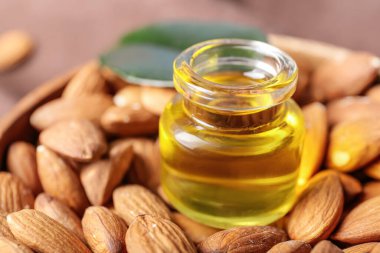 Bir şişe badem yağı ve fındık, yakın plan.
