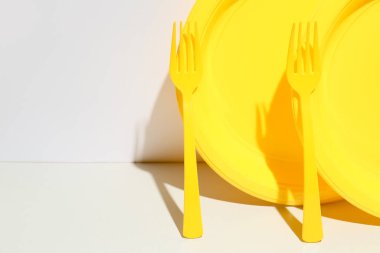 Renkli arka planda plastik çatallar ve plakalar