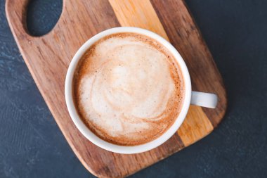 Koyu arkaplanda bir fincan lezzetli latte.