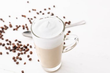 Hafif arka planda bir bardak lezzetli latte.