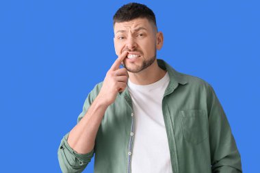 Arka planda diş ağrısı çeken bir adam.