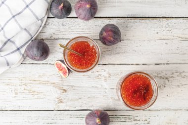 Beyaz ahşap masada tatlı incir reçeli kavanozları